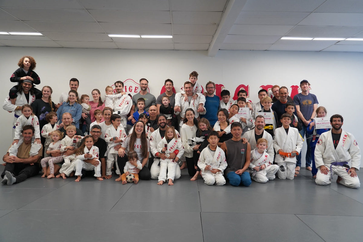 Brazilian Jiu-Jitsu students and instructors posing together at Origem BJJ academy