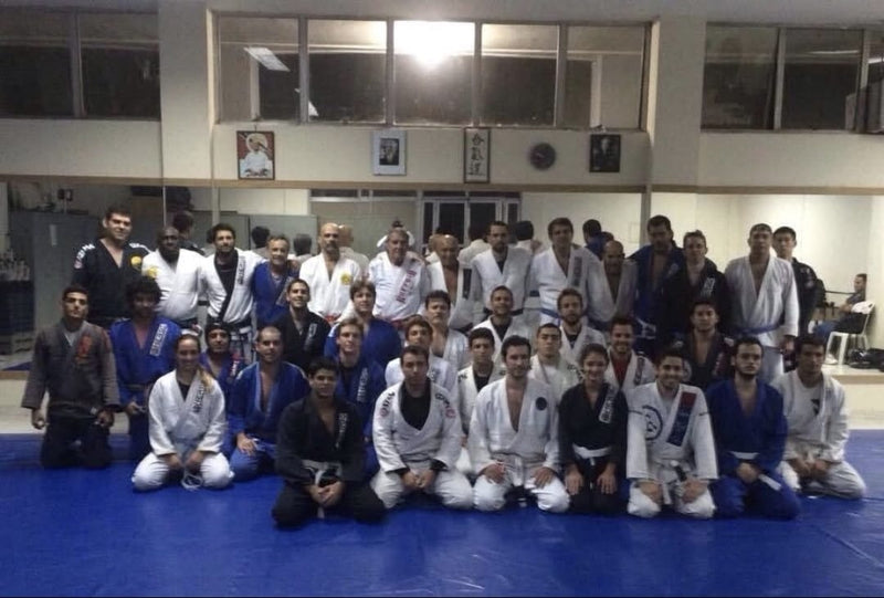 Brazilian Jiu-Jitsu students and instructors posing together for a group photo at a martial arts academy