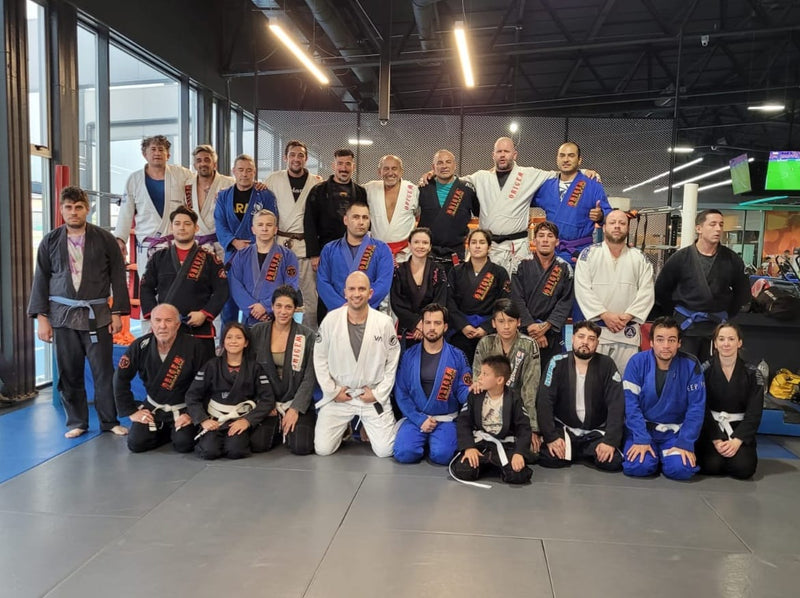 Brazilian Jiu-Jitsu students and instructors posing together for a group photo at a martial arts academy