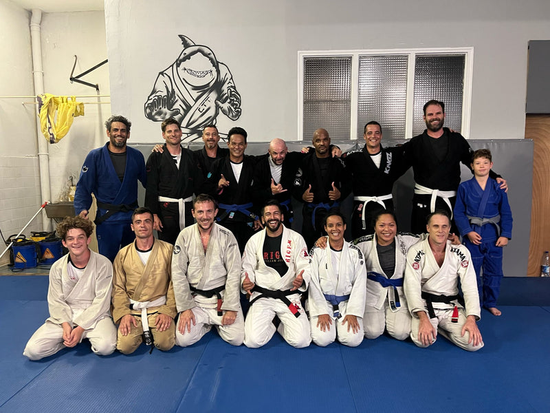 Brazilian Jiu-Jitsu students and instructors posing together at a martial arts academy